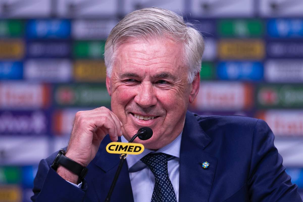 Carlo Ancelotti sorridente durante una conferenza stampa ufficiale con il Real Madrid nel 2025.