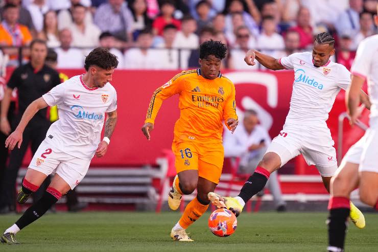 Endrick del Real Madrid in azione contro il Siviglia durante una partita della Liga 2025, contrastato da due difensori avversari.