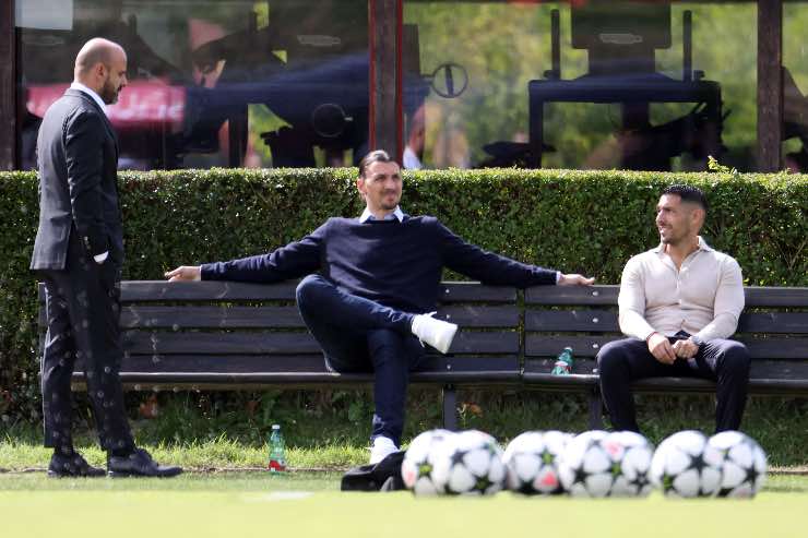 Zlatan Ibrahimovic e Geoffrey Moncada a bordo campo a Milanello nel 2025, durante un allenamento del Milan, in conversazione con un membro dello staff.