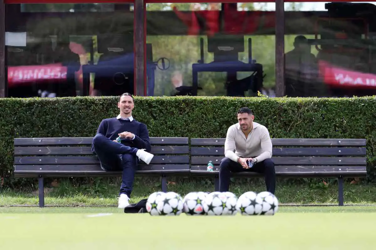 Zlatan Ibrahimovic e Geoffrey Moncada seduti a bordo campo a Milanello nel 2025, mentre osservano l’allenamento del Milan.