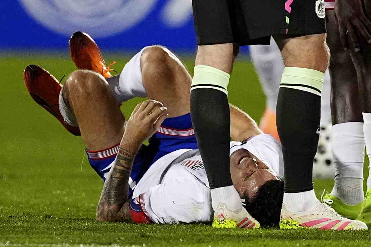 Christian Pulisic seduto a terra dopo un infortunio con la Nazionale degli Stati Uniti durante una partita del 2025