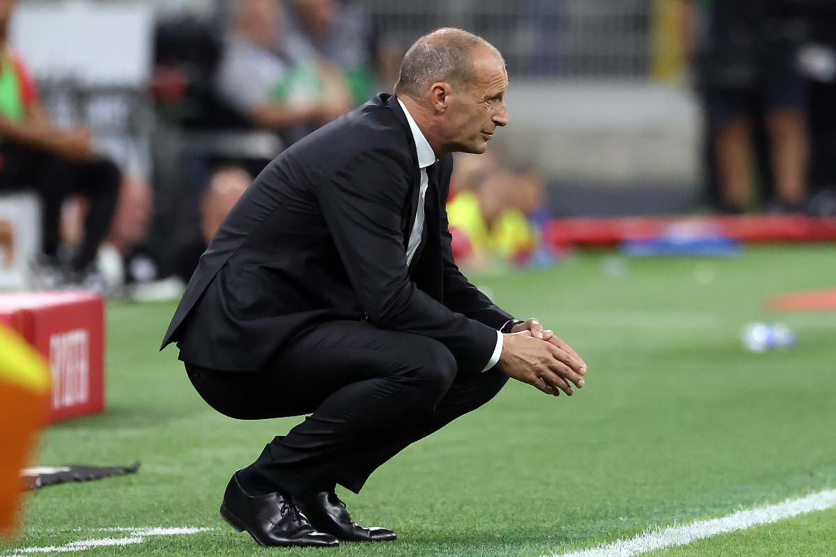 Max Allegri accovacciato nella sua area tecnica durante una partita del Milan