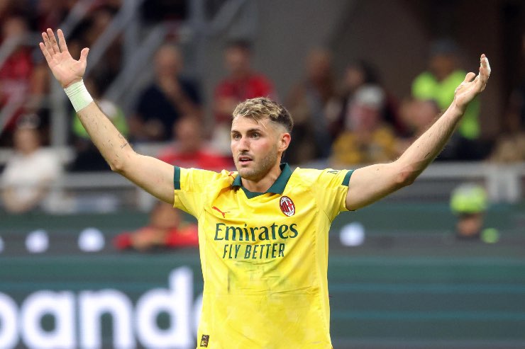 Santiago Gimenez del Milan esulta con le braccia alzate durante una partita di Serie A, indossando la maglia gialla da trasferta.