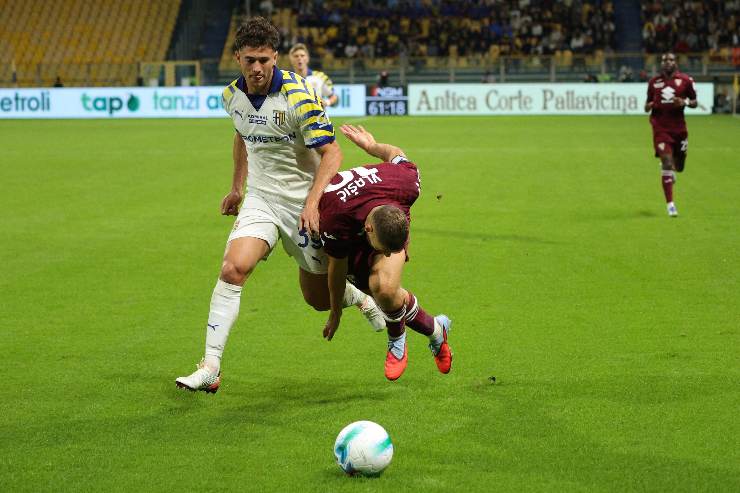 Azione di gioco tra un difensore del Parma e un attaccante del Torino durante un contrasto a centrocampo nella stagione 2025.