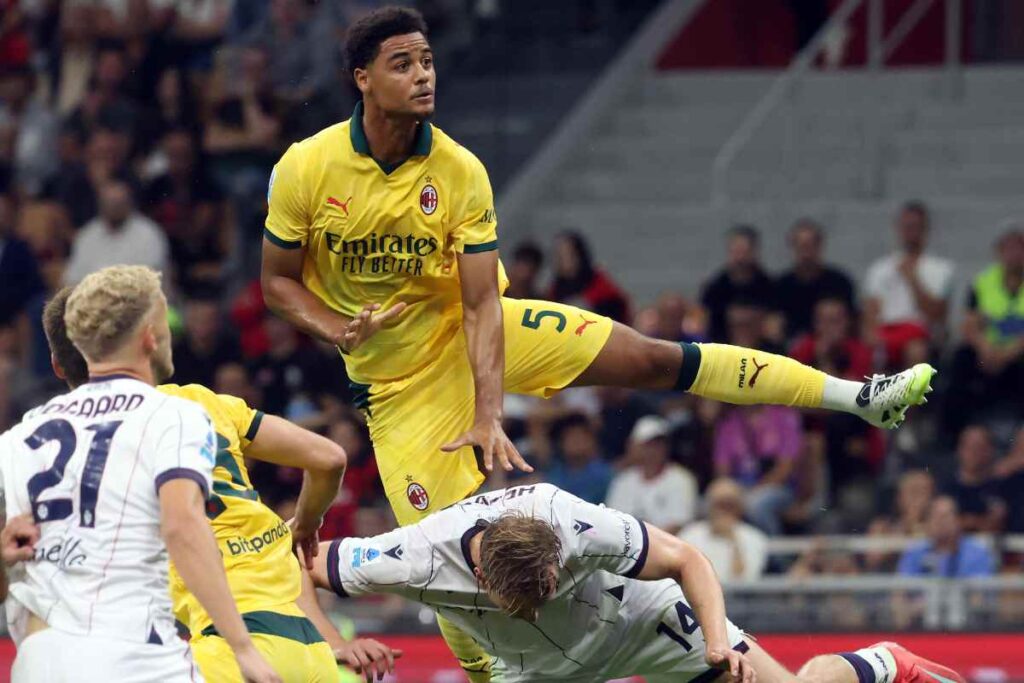 Koni De Winter del Milan salta sopra un avversario per colpire di testa con la maglia gialla nella stagione di Serie A 2025/2026.