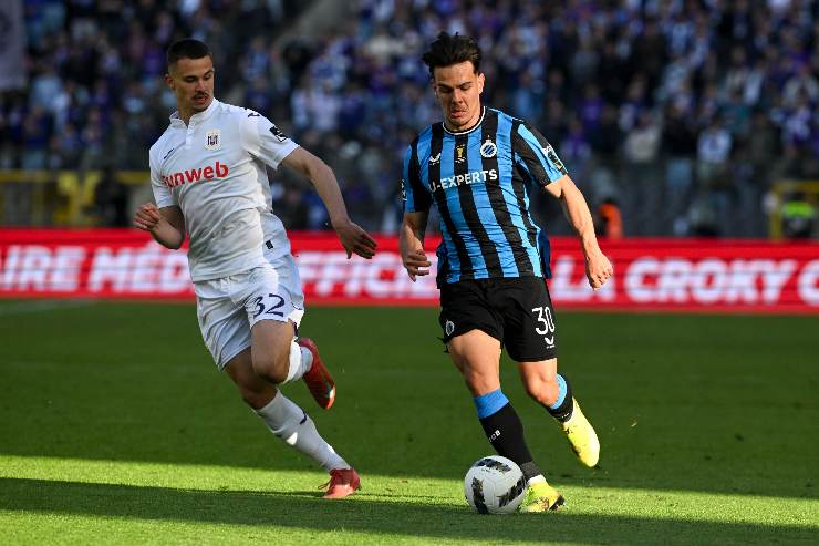 Ardon Jashari conduce palla in una partita del Club Brugge con un avversario in marcatura.