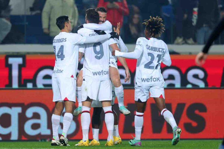 I giocatori del Milan esultano dopo un gol, indossando la maglia bianca da trasferta.