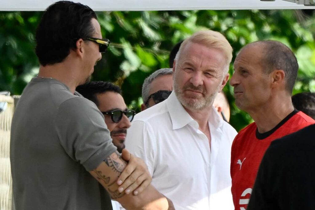Alcuni dirigenti del Milan e l’allenatore Massimiliano Allegri conversano all’esterno durante un incontro societario nel 2025.
