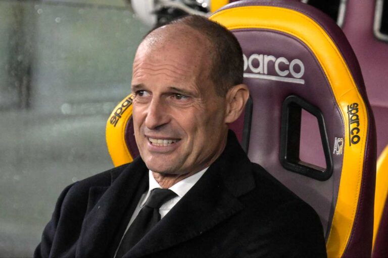 Massimiliano Allegri, allenatore del Milan, seduto in panchina durante una partita di Serie A nel 2026, con un'espressione concentrata.