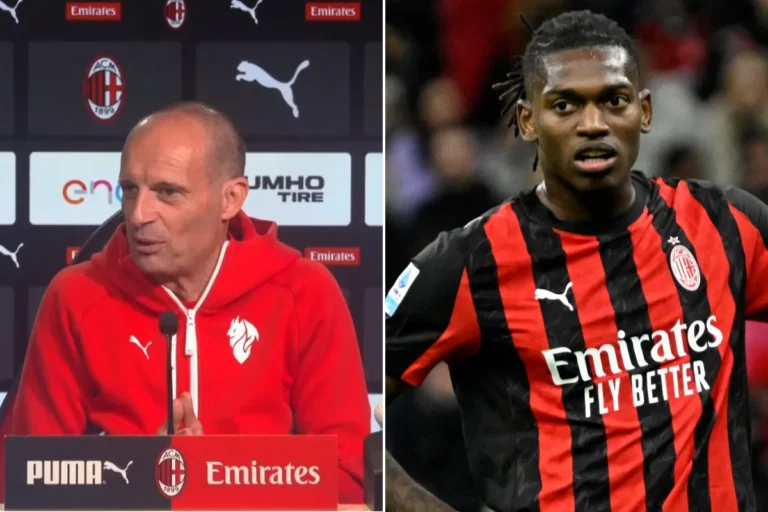 Massimiliano Allegri in conferenza stampa con la maglia rossa del Milan, accanto immagine di Rafael Leao in divisa rossonera