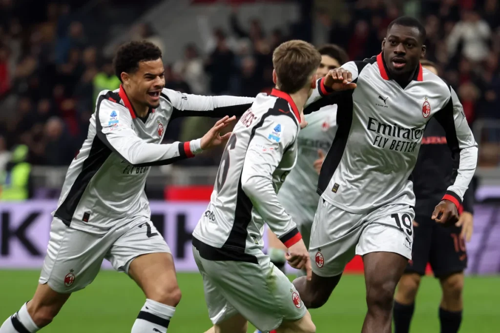 Giocatori del Milan in campo con maglietta bianca e rossa, esultanza durante la partita in stadio