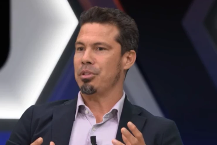 Hernanes durante un intervento televisivo su DAZN con microfono, abbigliamento formale