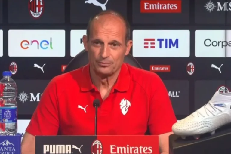 Max Allegri durante una conferenza stampa al Milan, indossa la polo rossa ufficiale