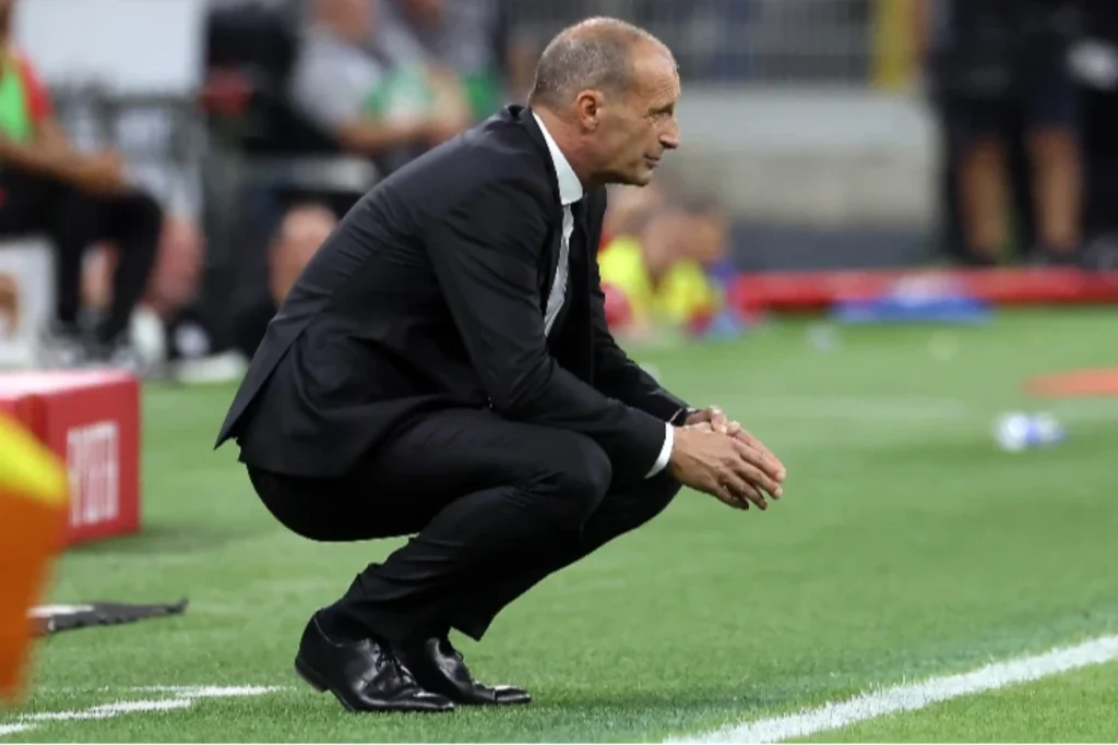 Massimiliano Allegri, allenatore del Milan, accovacciato vicino alla panchina nel corso di un match di Serie A
