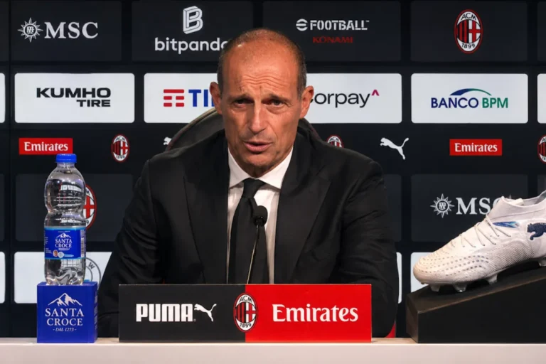 Massimiliano Allegri in conferenza stampa al San Siro con microfono davanti al logo Milan