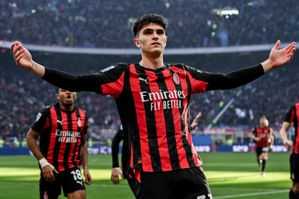 Bartesaghi esulta in campo con le braccia aperte, indossa la maglia rossonera del Milan