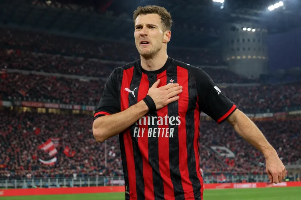 Leon Goretzka in maglia rossonera del Milan durante una partita, con la mano sul petto nello stadio