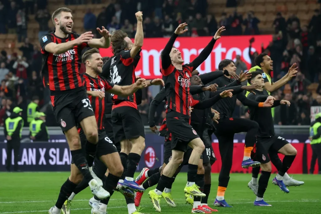 Giocatori del Milan esultano insieme sul campo durante la partita, con i bracci alzati in segno di celebrazione