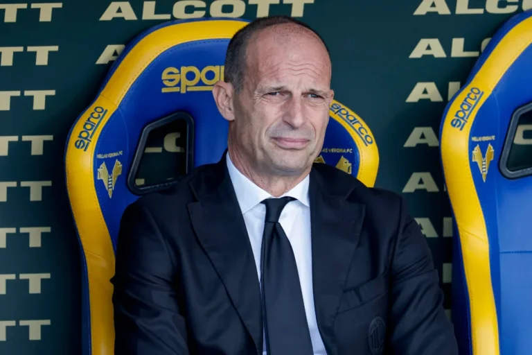 Massimiliano Allegri in panchina durante Milan-Atalanta, con sguardo concentrato in giacca e cravatta nera