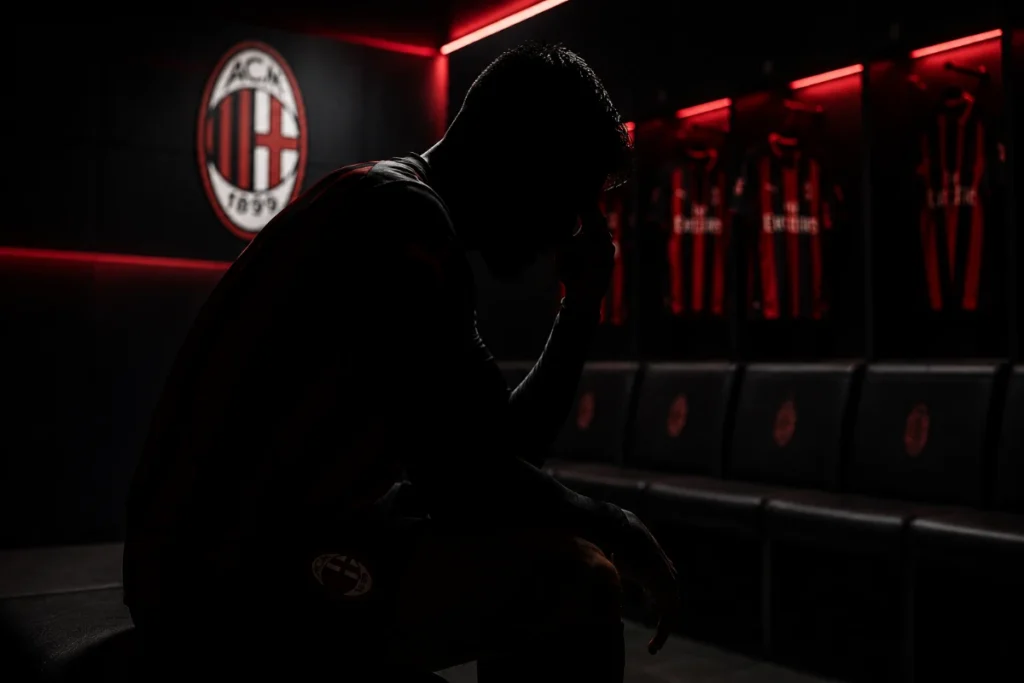 Christian Pulisic negli spogliatoi del Milan, in primo piano con il logo rossonero sullo sfondo