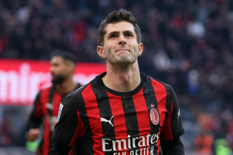 Pulisic in maglia Milan durante una partita, sguardo verso l'alto nello stadio