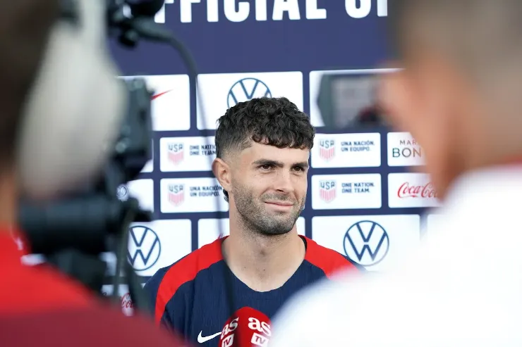 Pulisic in conferenza stampa con la maglia della nazionale USA, davanti a uno sfondo con sponsor ufficiali