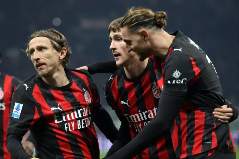 Rabiot, Modric e Saelemaekers del Milan in divisa rossonera durante una partita, con il centrocampista francese, il regista croato e l'esterno belga in comunicazione tattica