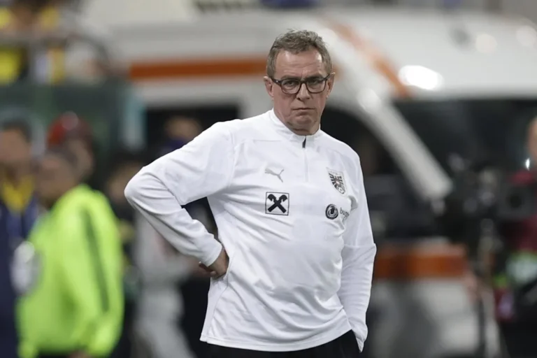 Ralf Rangnick in tuta tecnica bianca Puma in panchina durante una partita, con le mani sui fianchi