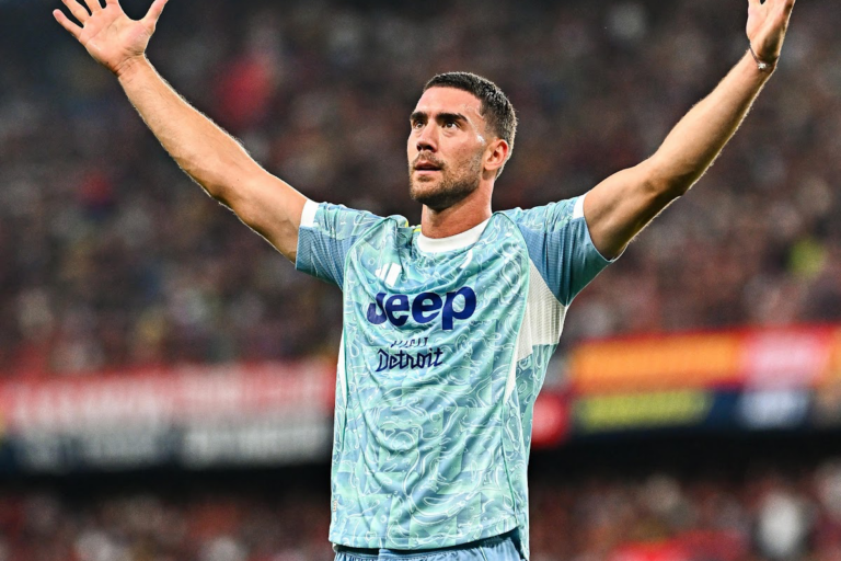 Vlahovic esulta con le braccia alzate indossando la maglia della Juventus durante una partita