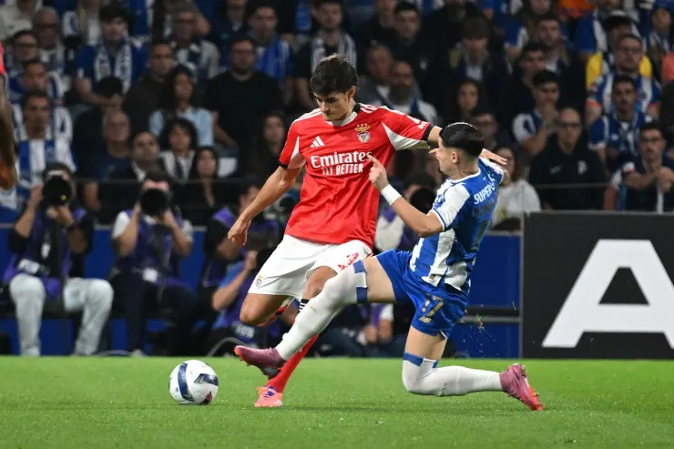 Antonio Silva in maglia rossa del Benfica contrasta un difensore in blu durante una partita di calcio