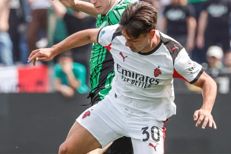 Jashari in azione con la maglia del Milan durante una partita, contrastato da un avversario in verde