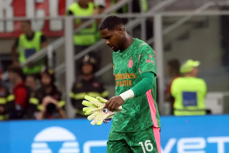 Mike Maignan portiere del Milan in maglia verde durante una partita, con lo sguardo rivolto verso il basso
