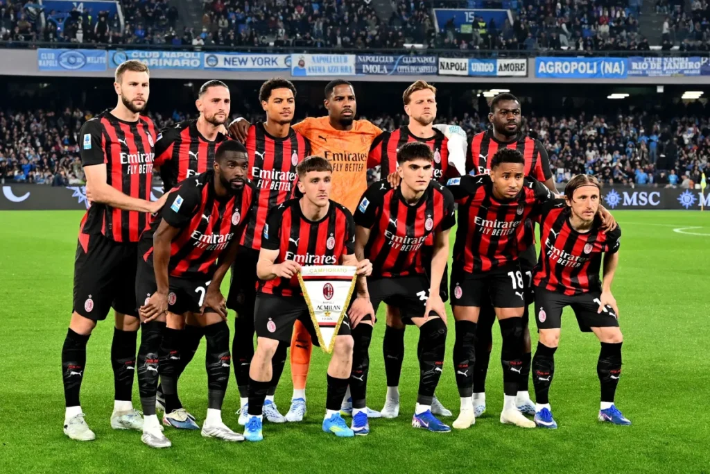 Squadra del Milan in formazione pre-partita con 11 giocatori in maglia rossonera e portiere in divisa arancione