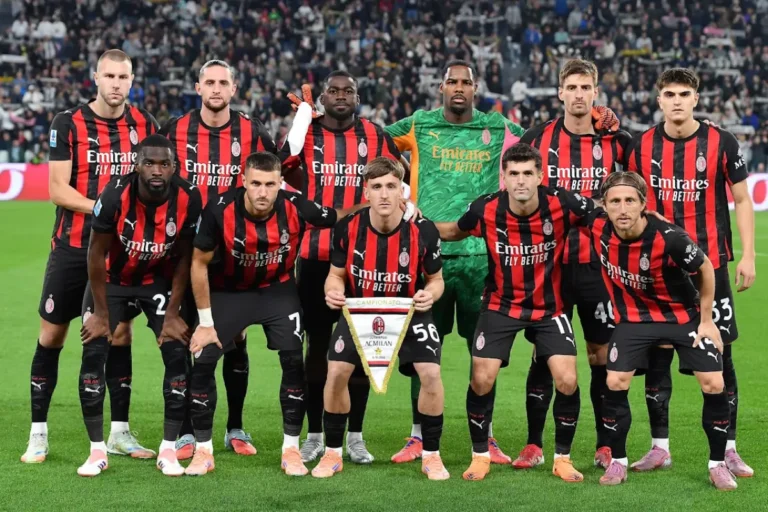 Squadra del Milan schierata in posa ufficiale sul campo prima della partita, con undici giocatori in divisa rossonera e portiere in maglia verde