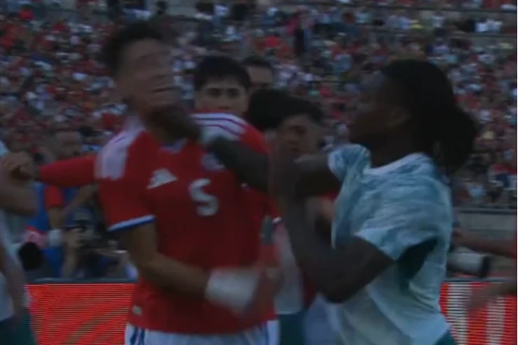 Rafael Leão in maglia rosso-blu durante una partita, protagonista di un contatto con un avversario in maglia celeste