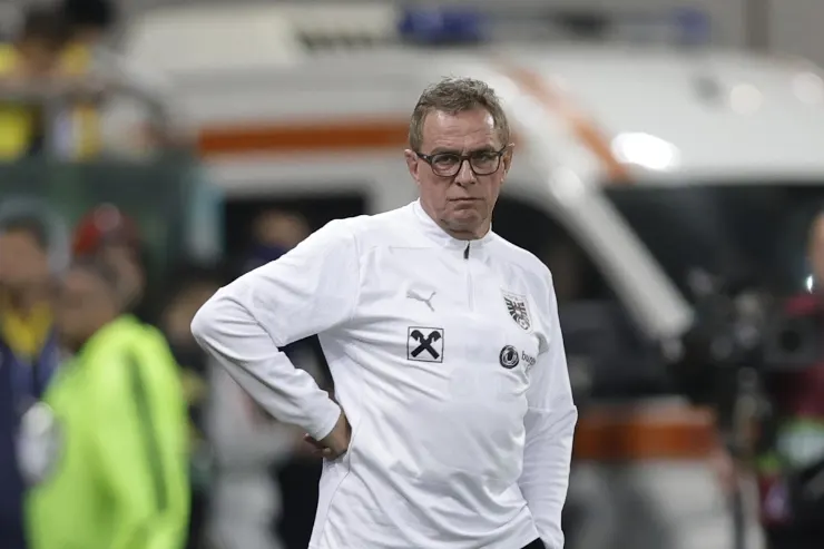 Rangnick in tuta bianca da allenatore durante una partita, con le mani sui fianchi