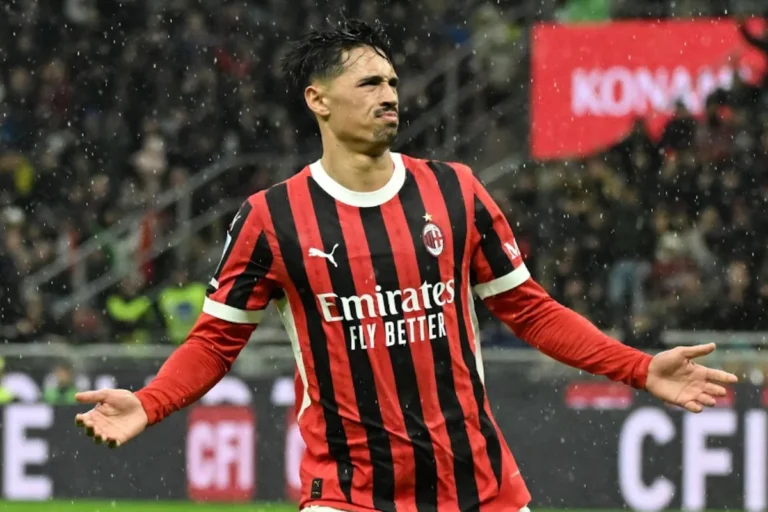 Reijnders in maglia rossonera durante una partita, con le braccia aperte sotto la pioggia