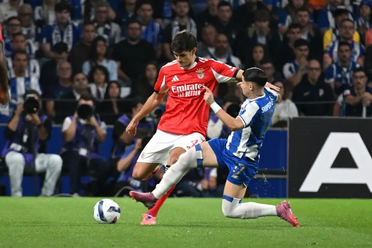 Antonio Silva in maglia rossa del Benfica contrasta un avversario in maglia blu durante una partita di calcio