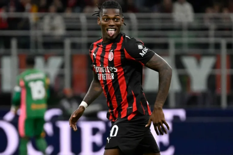 Rafael Leão esulta in campo con la maglia del Milan a righe rosse e nere, lingua fuori in un gesto di gioia