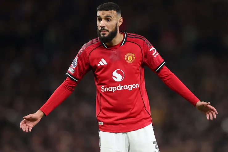 Mazraoui in maglia Manchester United rossa durante una partita, con lo sponsor Snapdragon visibile