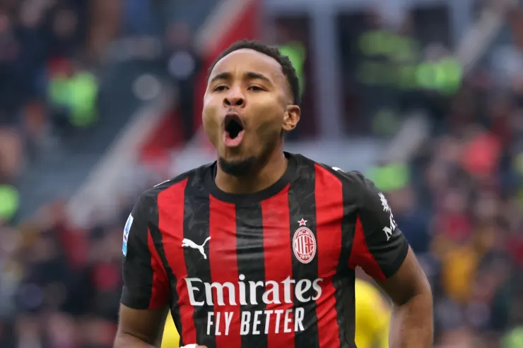 Nkunku esulta durante una partita del Milan, indossa la maglia rossonera con lo sponsor Emirates