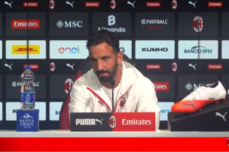 Amorim durante una conferenza stampa al Milan, davanti al backdrop con sponsor Emirates e Puma