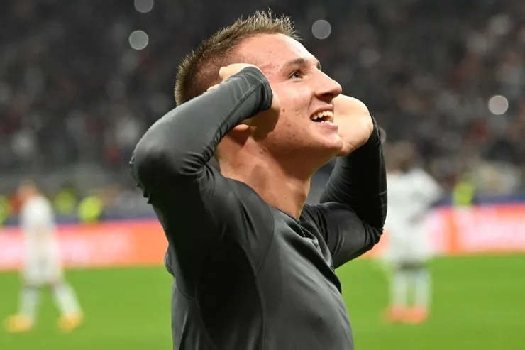 Camarda esulta durante una partita del Milan, con le mani portate alle orecchie in segno di gioia