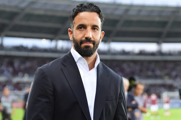 Amorim in abito scuro e camicia bianca nello stadio durante una partita di calcio
