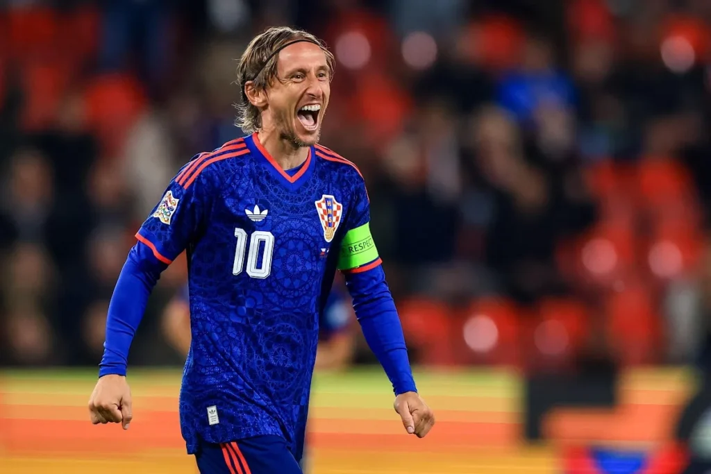 Luka Modric con la maglia della Croazia numero 10 sorride durante una partita, indossando la fascia di capitano