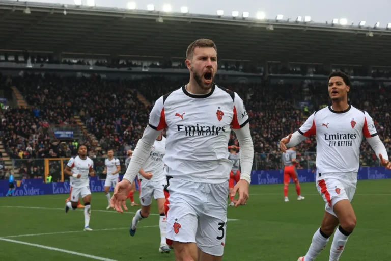 Pavlovic esulta durante una partita del Milan, indossa la maglia bianca e rossa dei Rossoneri