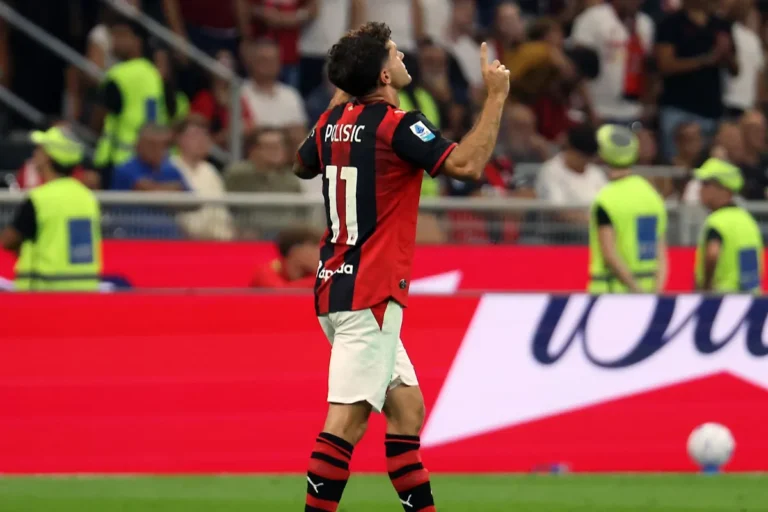 Pulisic con la maglia rossonera numero 11 durante una partita al Meazza, esulta rivolto verso il pubblico