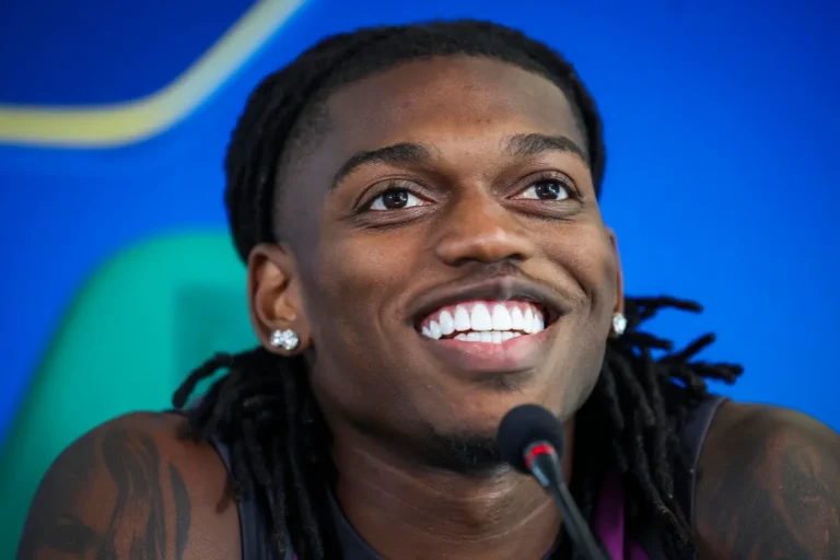 Rafael Leao sorride durante una conferenza stampa con microfono davanti
