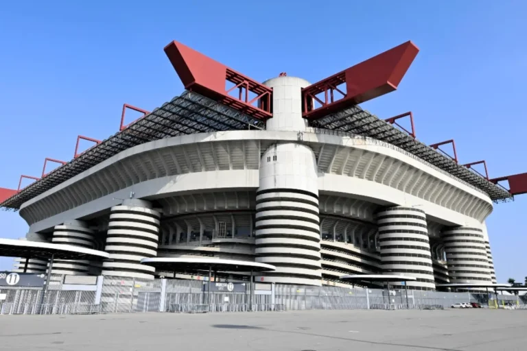 Stadio San Siro di Milano, impianto iconico del Milan con caratteristici anelli bianchi concentrici, colonne a strisce e coperture metalliche rosse