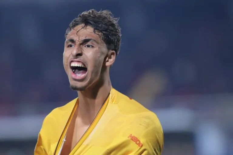 Tiago Gabriel con espressione celebrativa indossa giacca gialla con logo, momento di gioia